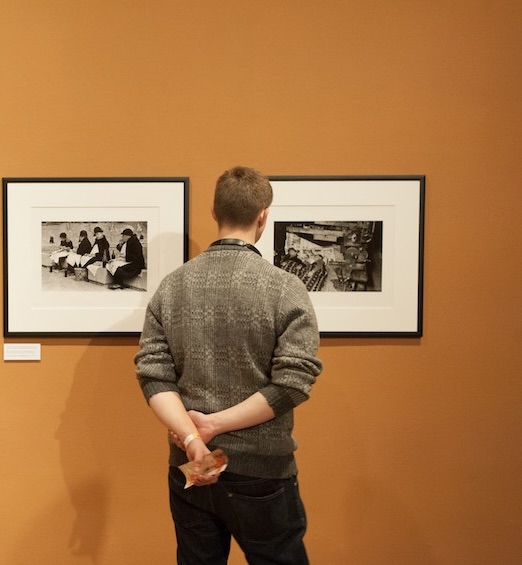 Man looking at photos at museum